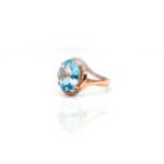Side view of rose gold plated 925 silver oval blue topaz halo ring showing split shank and accent stones – L66648