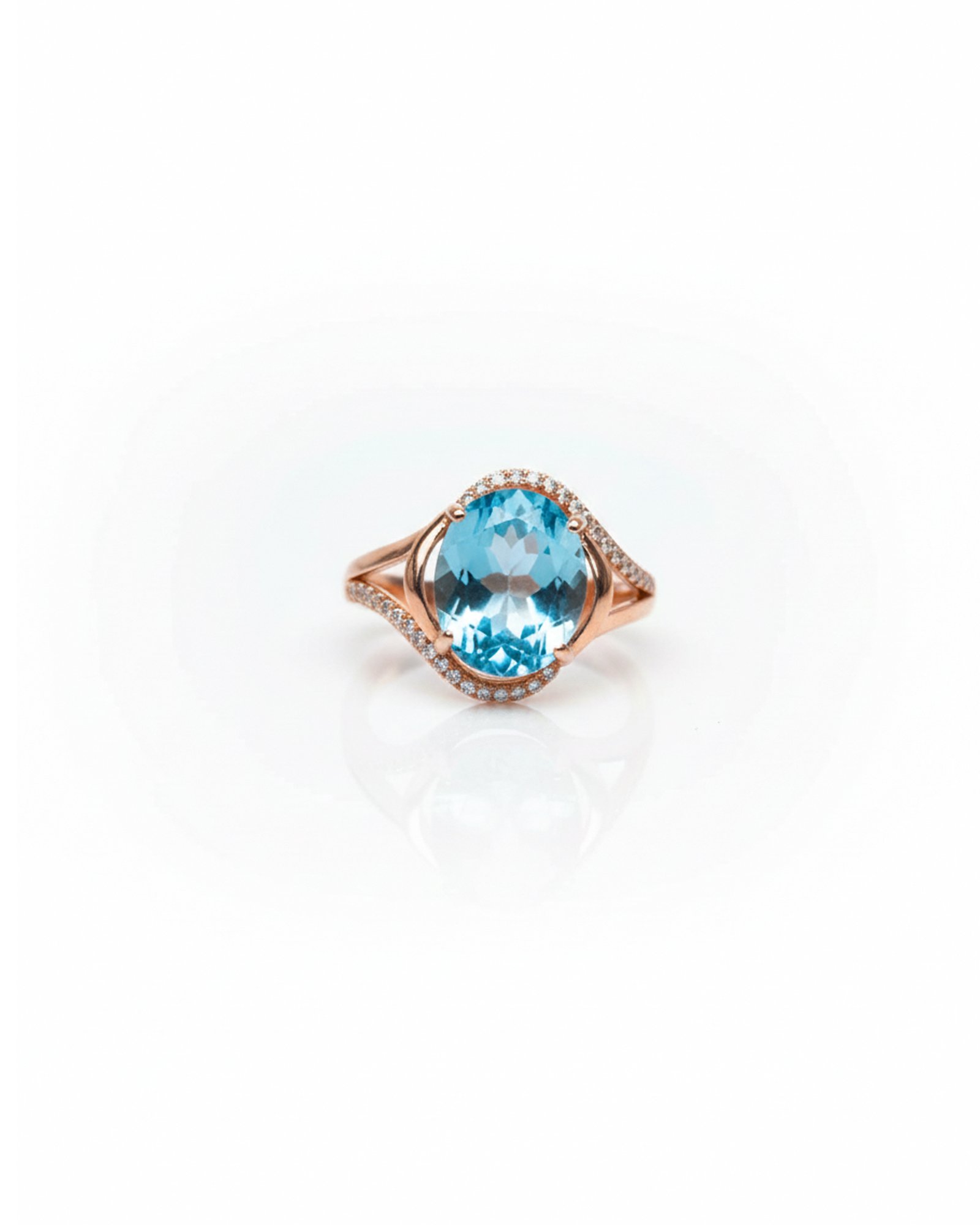 Front view of rose gold plated 925 silver oval blue topaz halo ring with split shank and accent stones – L66648
